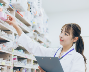 薬剤師が薬棚に手を伸ばしている